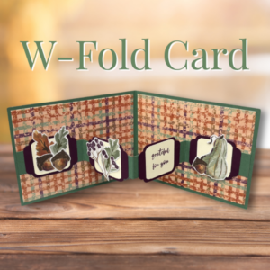 W-Fold card in autumn colors, opened to show four panels with a green plaid background, layered acorn and gourd die cuts, a purple floral accent, and a 'grateful for you' sentiment panel, displayed on a wood surface